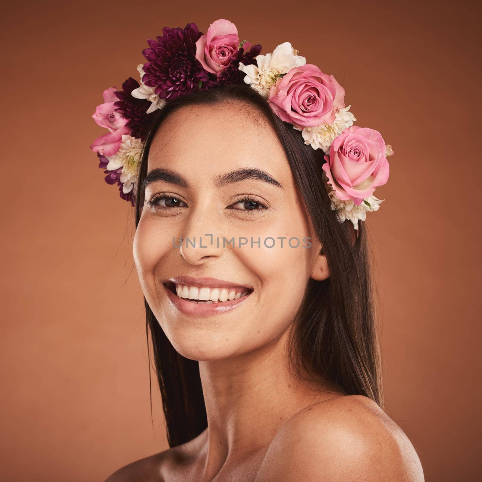 Woman, beauty smile and flower headband for spring portrait. Young happy girl, natural cosmetic makeup and healthy facial skincare wellness glow with floral rose band in orange background studio by YuriArcurs