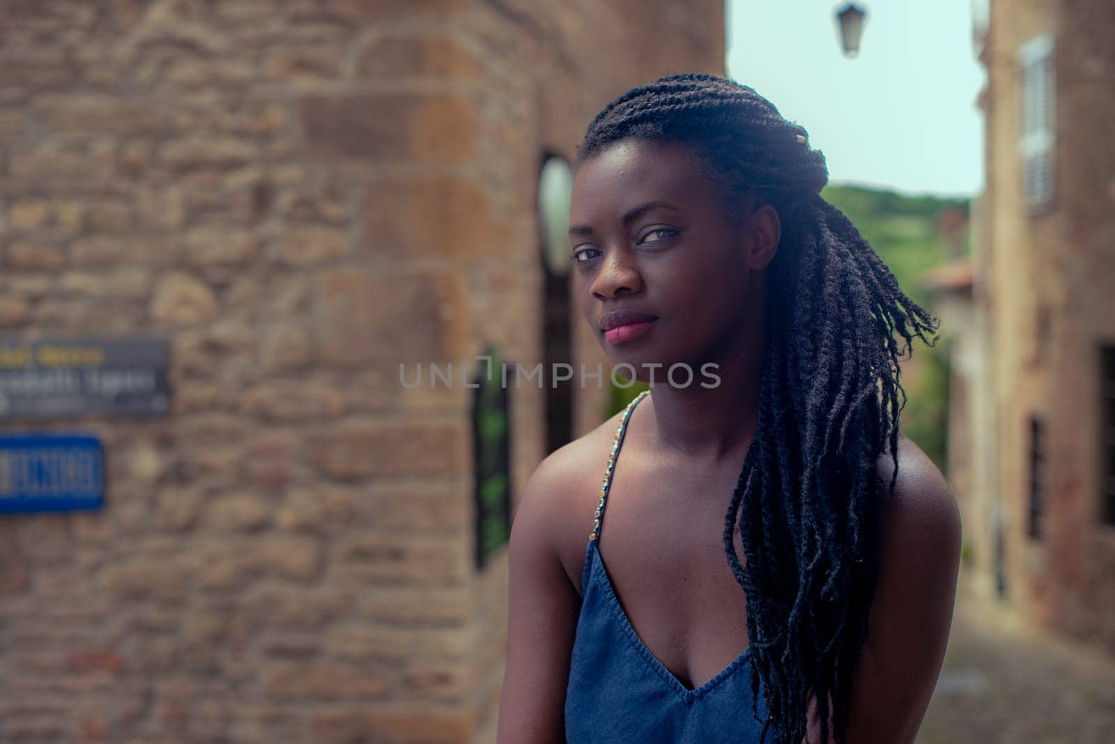 relaxed young black woman sitting. Stylish model. Braid dreadlock hairstyle. Confident African female in selective focus outdoors, fashion style, happiness concept. Outdoors.