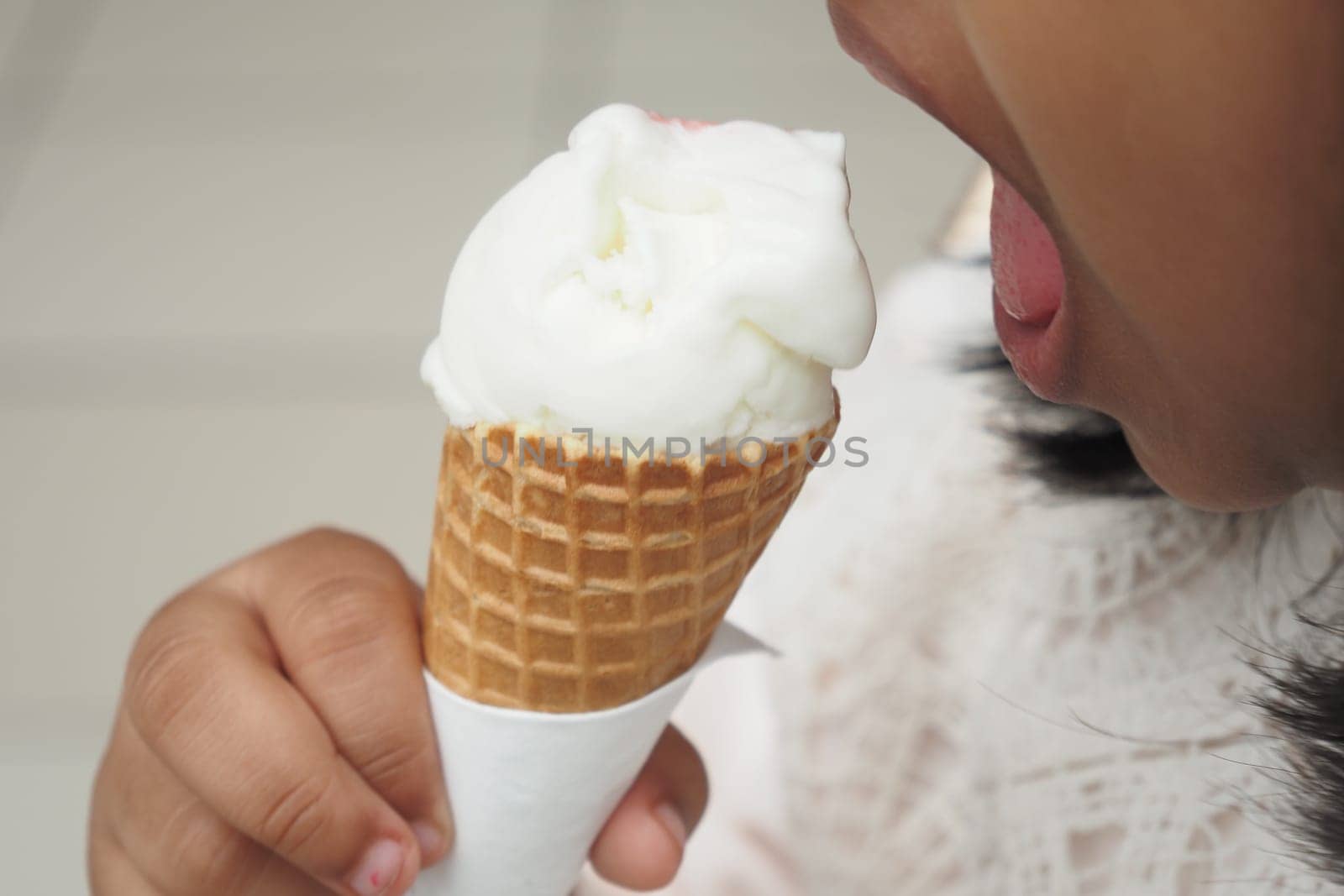 Child Hand Holding Vanilla Ice Cream in A Waffle Cone