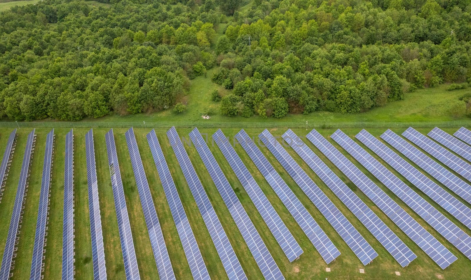 aerial shot of a group of photovoltaic solar panels in the countryside by verbano