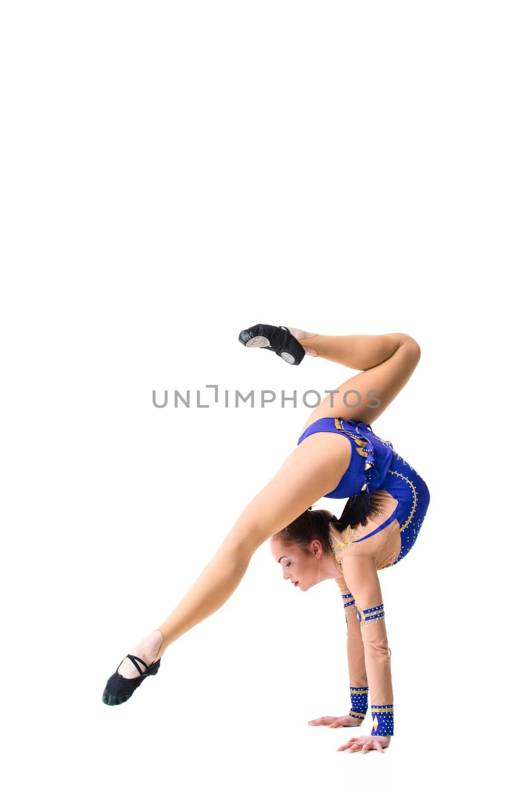 Young girl doing gymnastic exercises isolated. The girl in a blue dancing suit