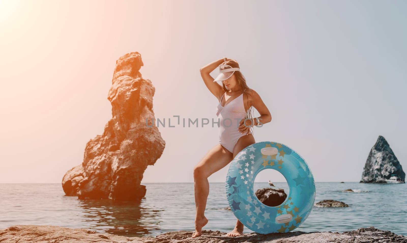 Woman summer sea. Happy woman swimming with inflatable donut on the beach in summer sunny day, surrounded by volcanic mountains. Summer vacation concept. by panophotograph