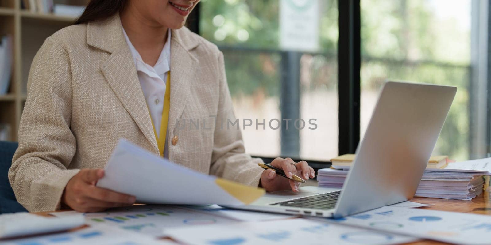 Asian Business person makes analysis and research financial report at office, analyzes profits. Accountant checks status of financial.