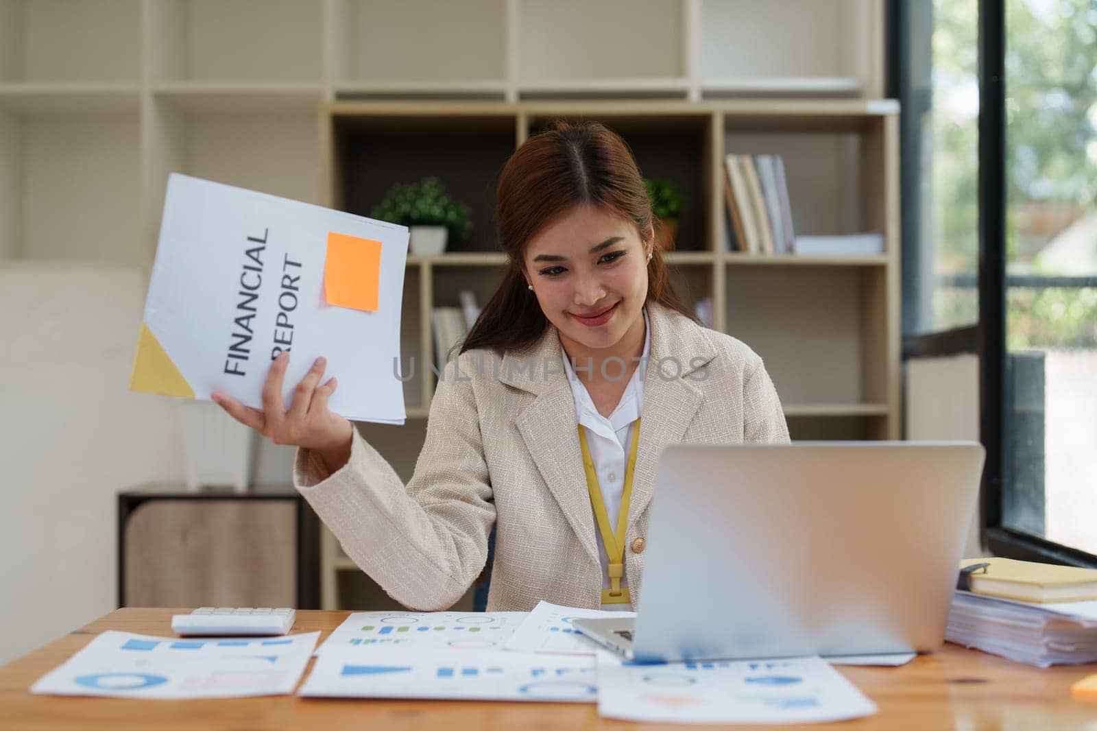 Asian Business person makes analysis and research financial report at office, analyzes profits. Accountant checks status of financial.