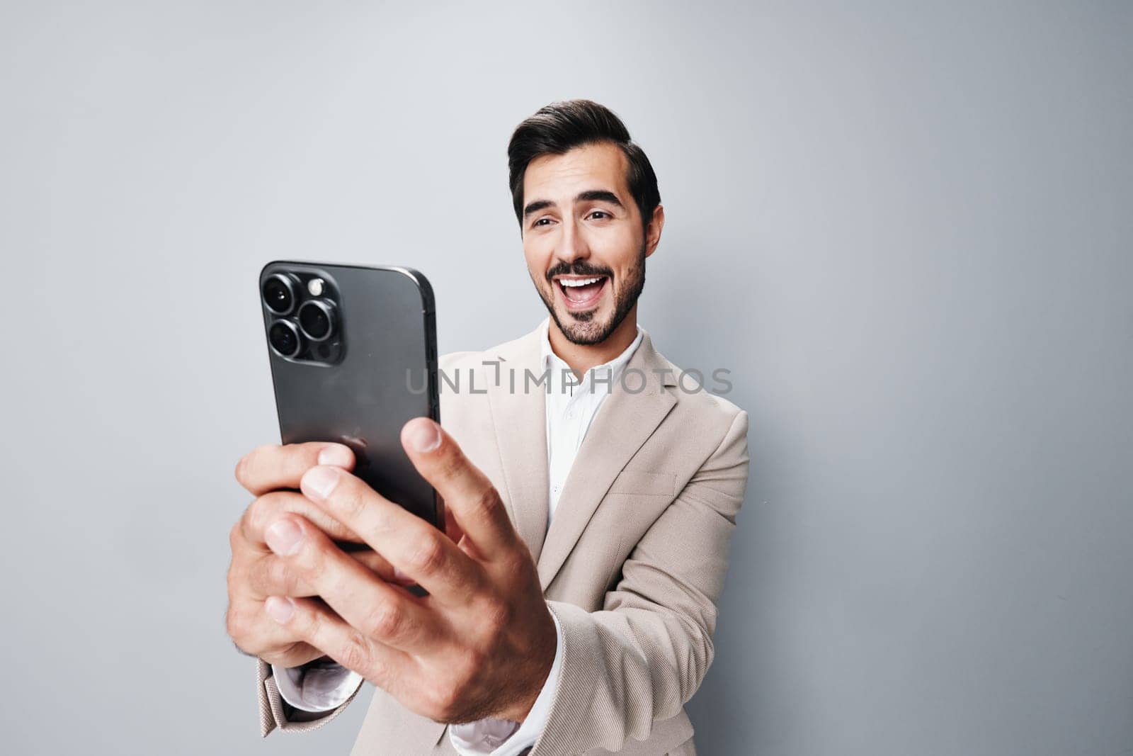 suit man success internet portrait smartphone connection studio business happy technology isolated phone confident hold lifestyle online entrepreneur handsome smile call