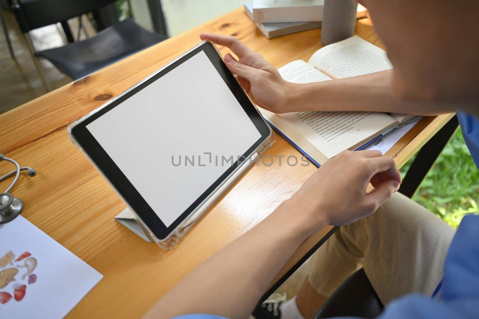 Closeup view of medical student man using digital tablet, preparing for university exams in library.