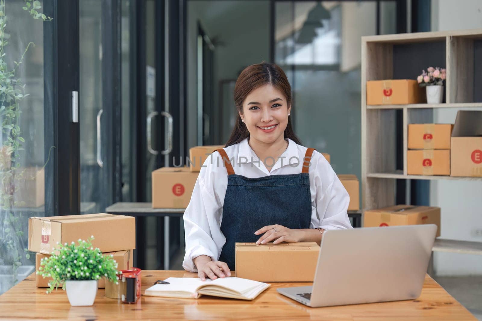 Happy young asian woman startup small business computer laptop and sitting on chair, Online marketing packing box delivery concept.