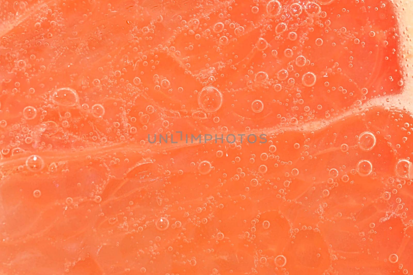 Slice of ripe grapefruit in water. Close-up of grapefruit in liquid with bubbles. Slice of ripe grapefruit in sparkling water. Macro horizontal image of fruit in carbonated water