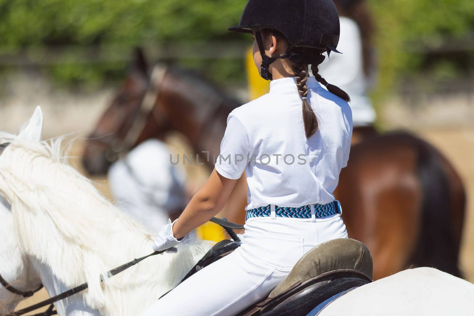 Equestrian sport - a little girl on a horseback at the ranch. Mid shot