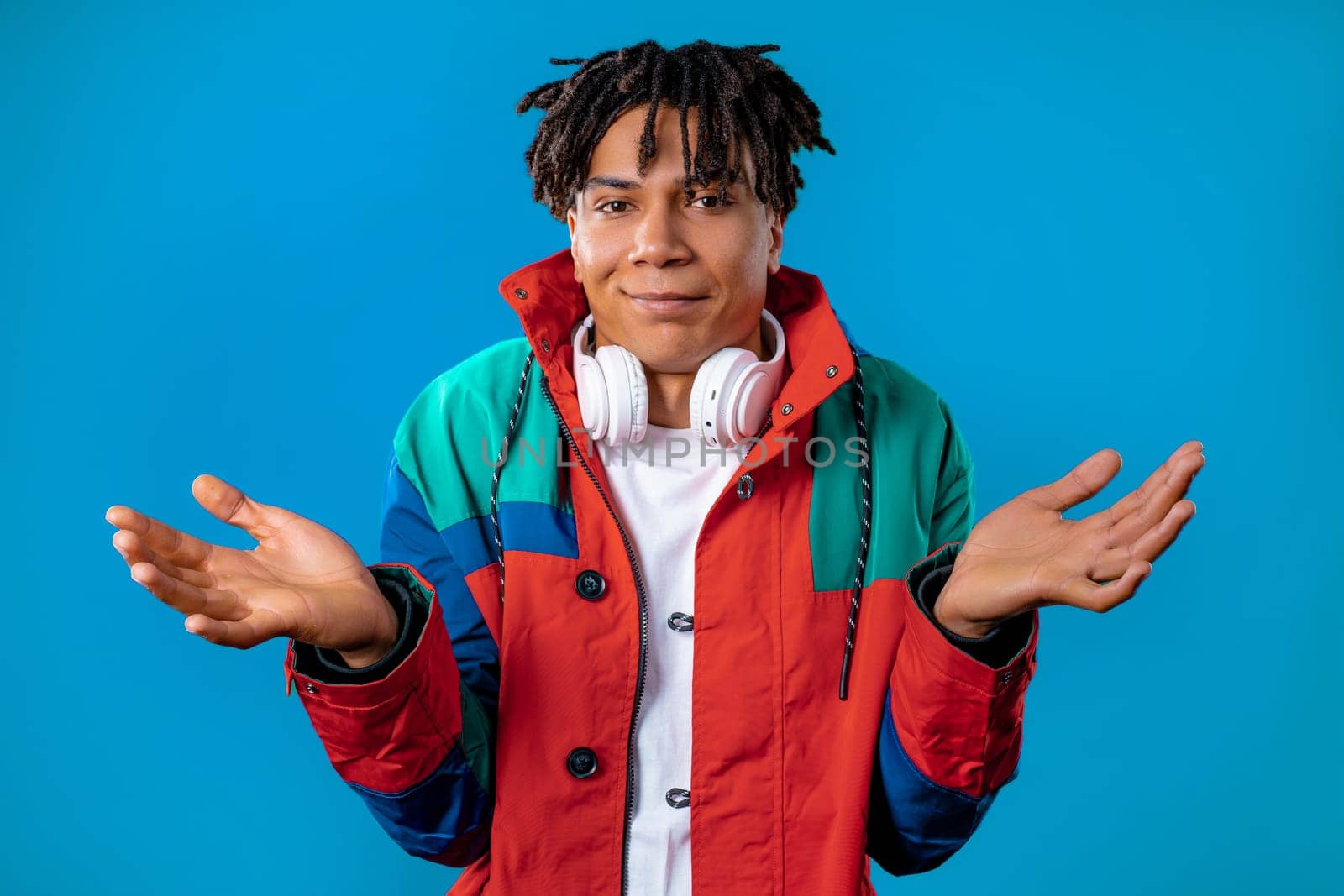 Confused man, shoulders up - can't help, makes gesture of I dont know. Difficult question, guilty reaction, puzzled teenage guy on blue background. High quality