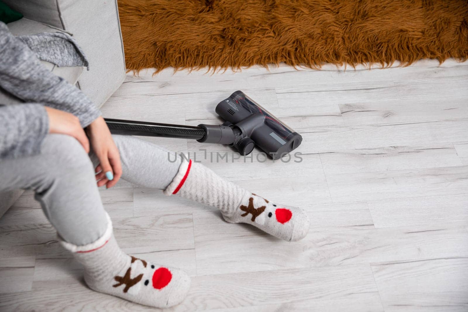 The girl sat on the sofa to relax after vacuuming the entire apartment. Cleanliness and order requires regularity throughout the apartment.
