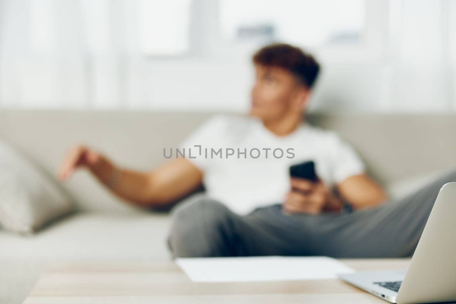 man interior modern young curly cellphone selfies blissful holding person mobile sofa cell lifestyle