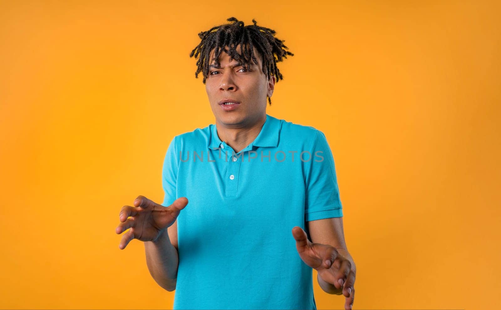 Frightened shocked african man afraid of something and looks into camera with big eyes full of horror on yellow background. Phobia, trouble, panic concept. High quality photo