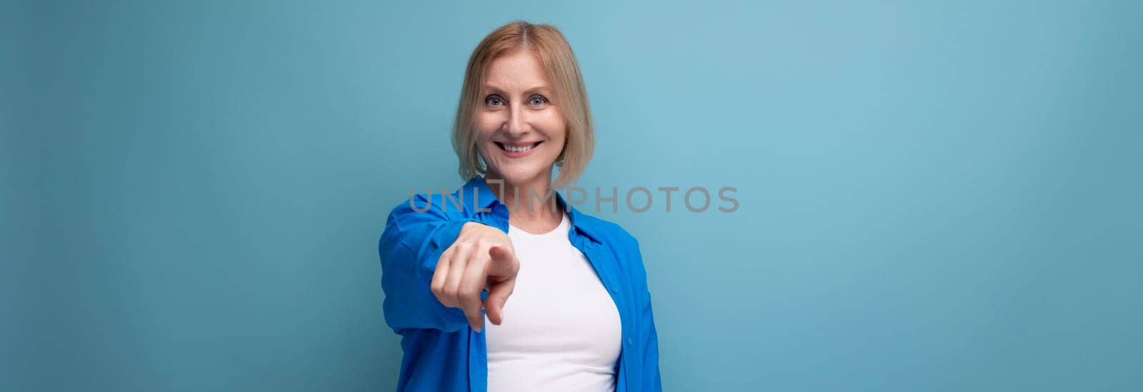 panoramic photo of confident middle aged woman in blue stylish shirt on studio background by TRMK