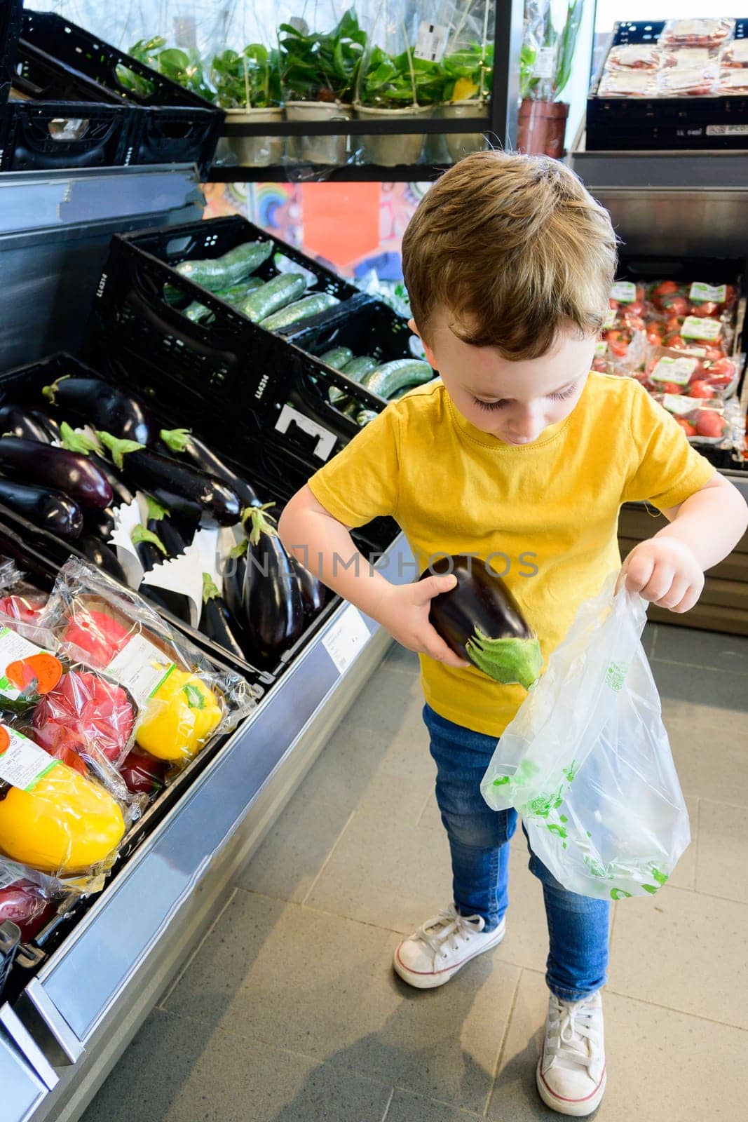 Little child choosing vegetables in a food store or supermarket. Healthy food. Healthy life. Healthy body. Healthy nutrition by jcdiazhidalgo