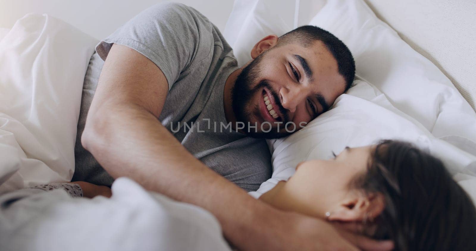 Face, happy man and relax with woman in bed, room and enjoy romance of quality time together at home. Couple, relationship and bonding in morning for love, care and happiness for partner on honeymoon.
