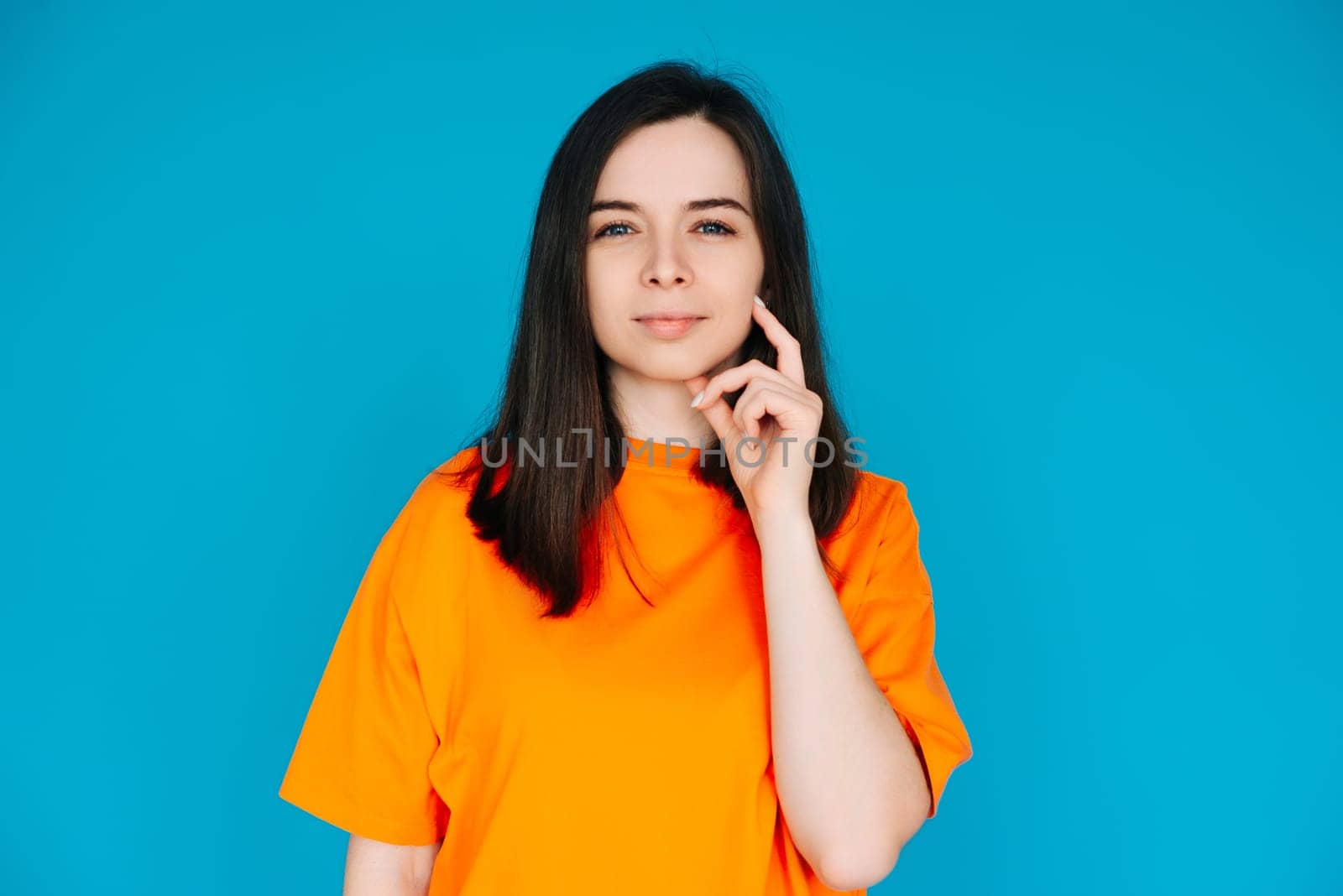 Thoughtful Woman Touching Chin, Contemplating, Copy Space, Isolated on Blue Background. Portrait of a Beautiful Woman Touching Her Chin, Contemplating.