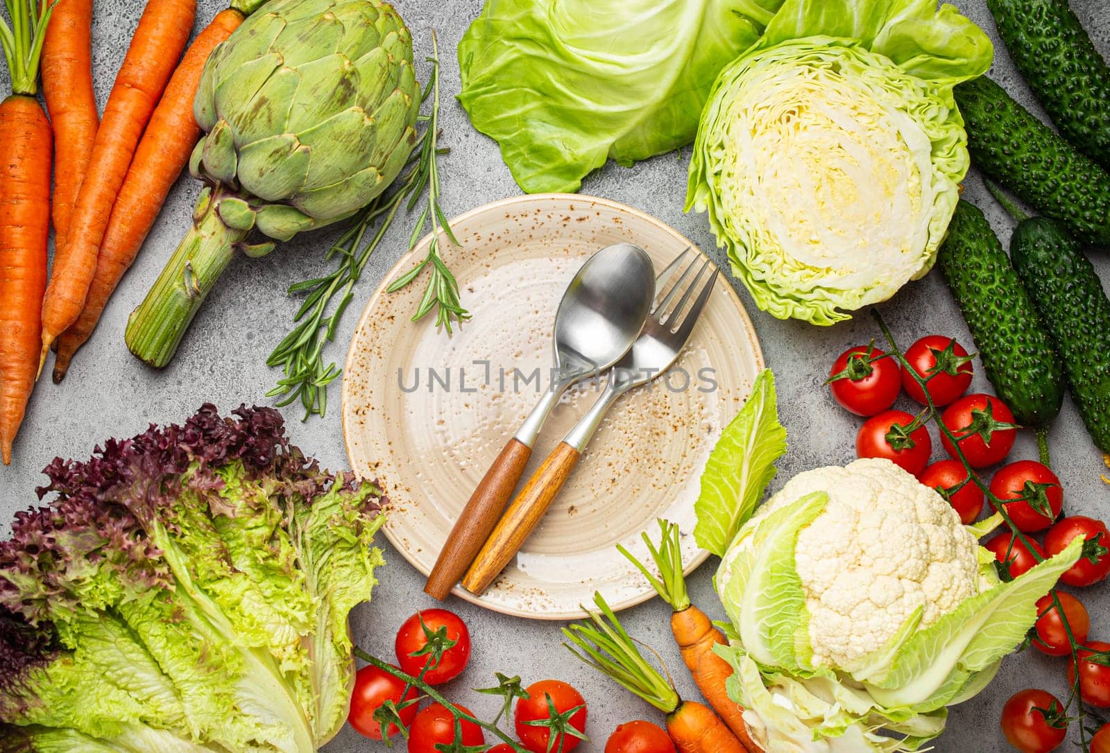 Assorted food raw products: vegetables, beef meat, fish salmon and empty plate in centre, light rustic stone table top view copy space. Healthy food background, ingredients for balanced diet.