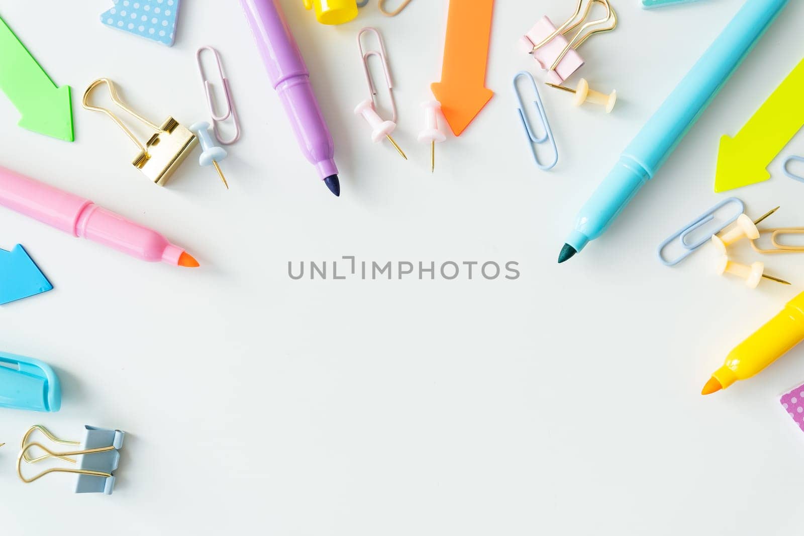 Top view of bright colored school supplies with blank paper for mockup or text