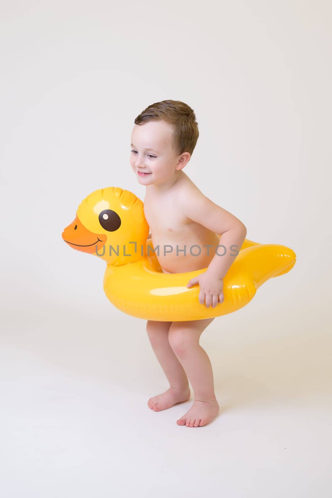 adorable boy with a float on a white background.