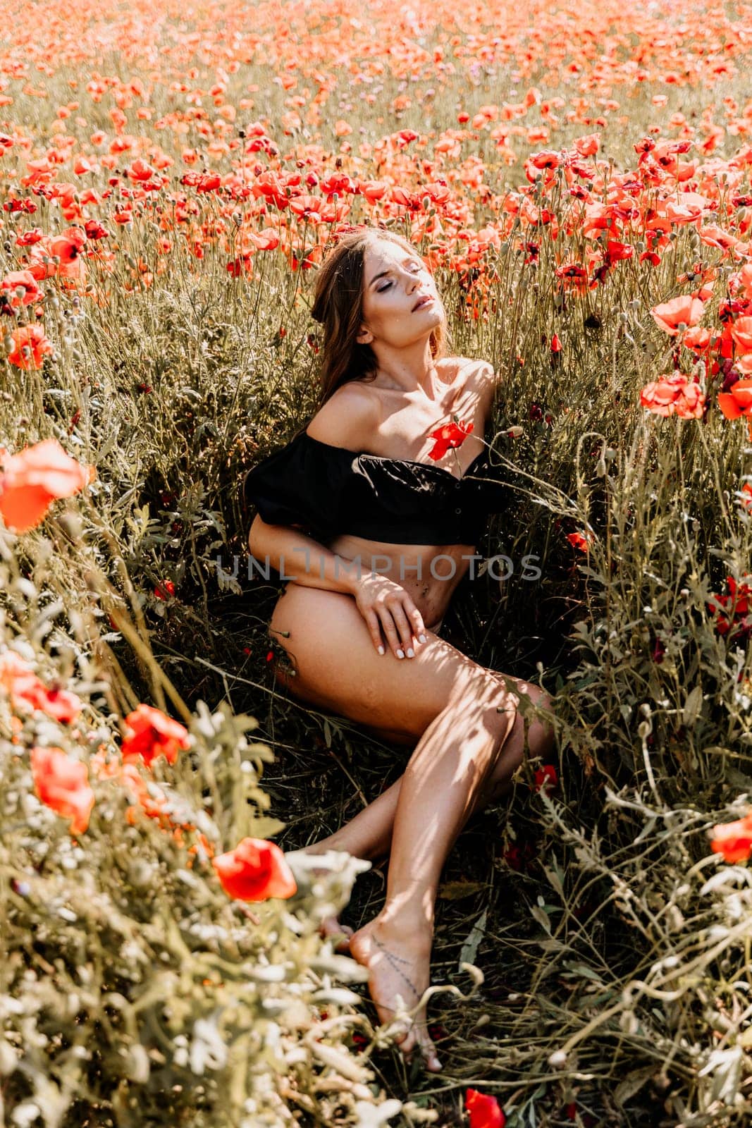 Woman poppies field. Happy woman undressed lies in a red poppy field, summer time.