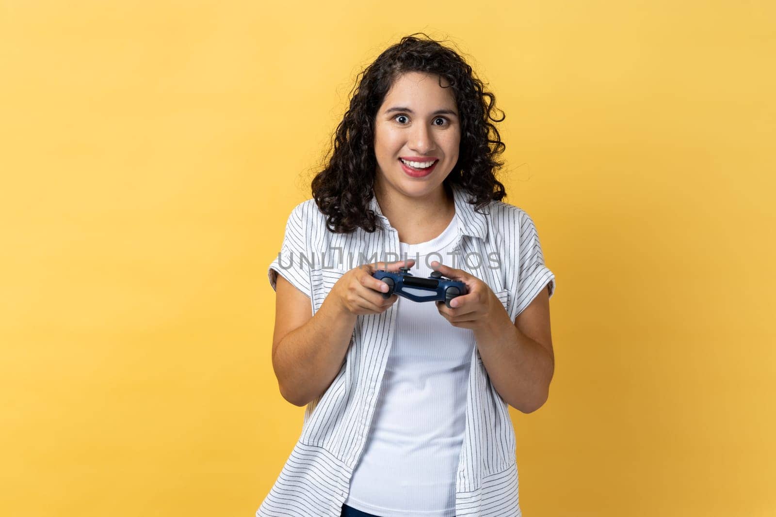 Woman holding gamepad, winning video games competition, looking at camera with happy expression by Khosro1