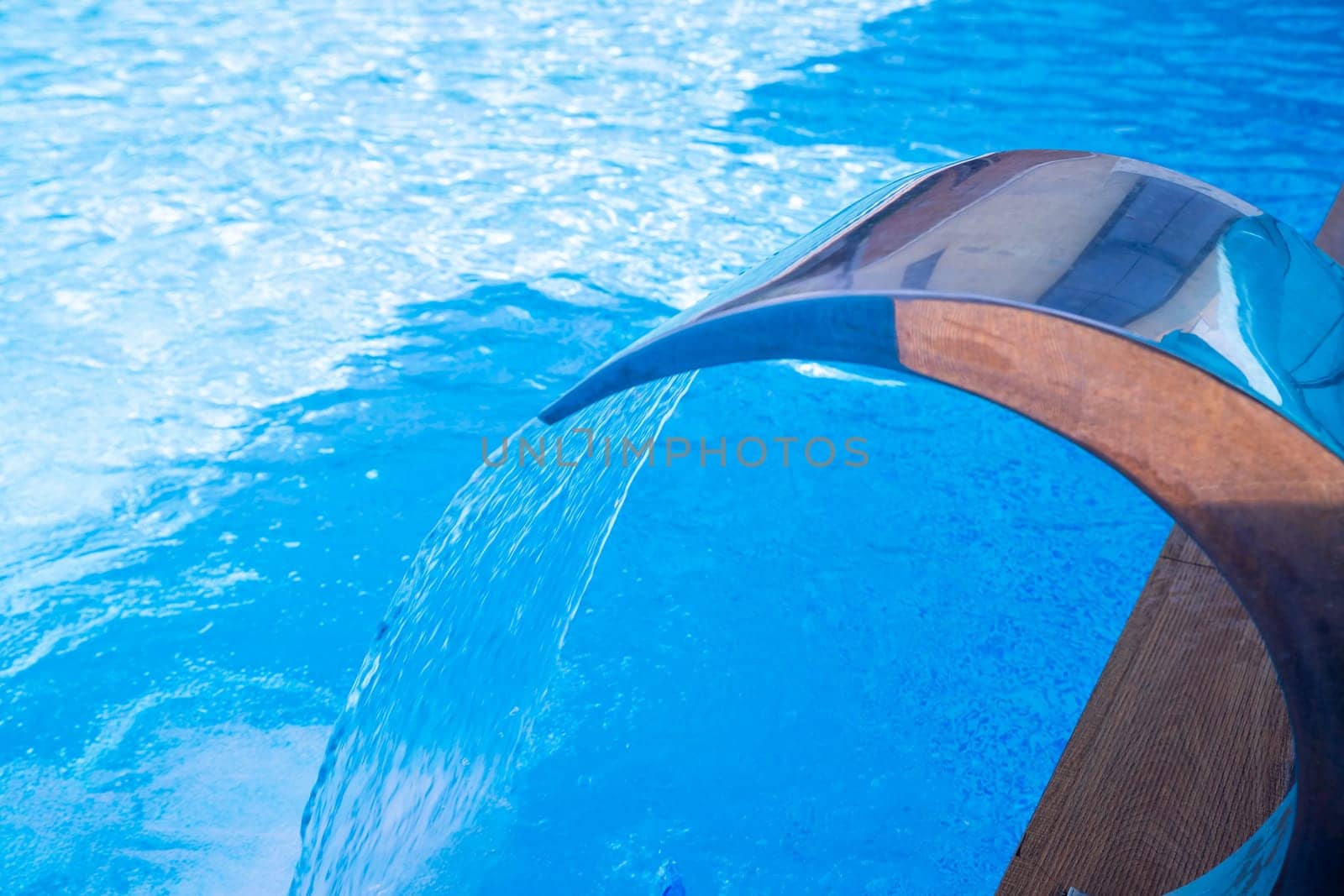 Empty Swimming pool with waterfall jet and jacuzzi in action