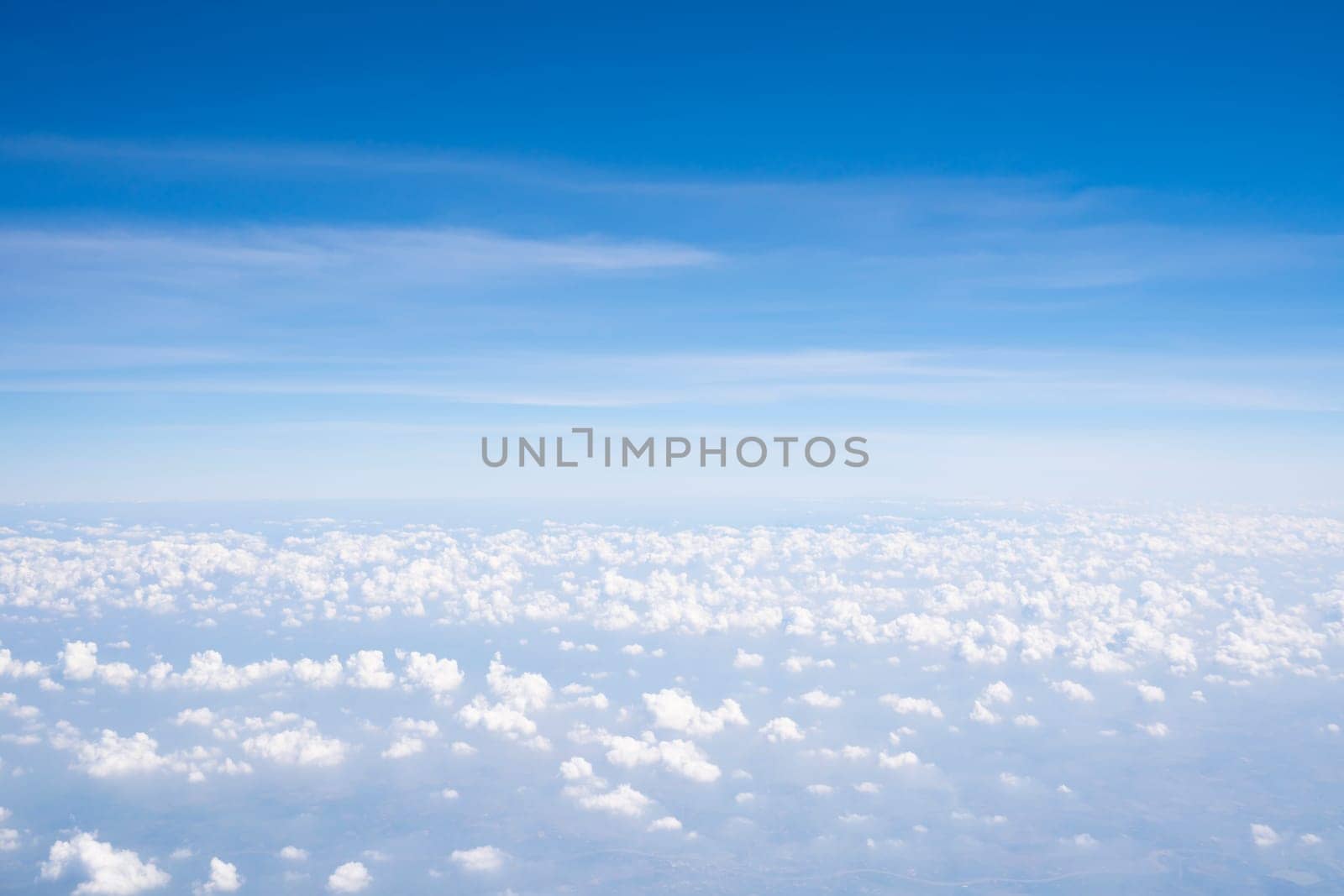 Aerial view of Fluffy clouds Top view from airplane window, Nature background.