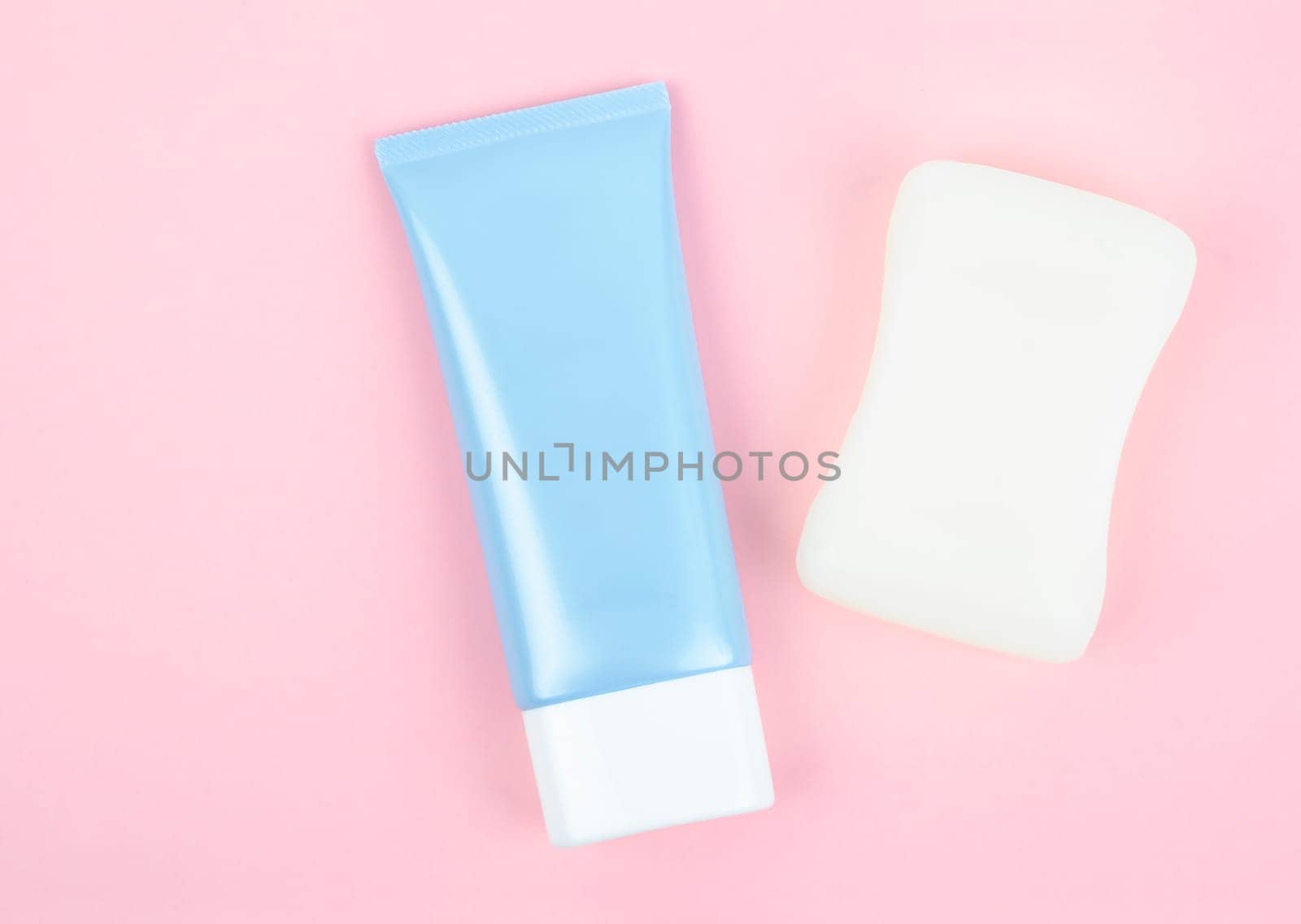 op view blue squeeze bottle plastic tube and herb soap bar on beautiful background for branding of medicine or cosmetics.