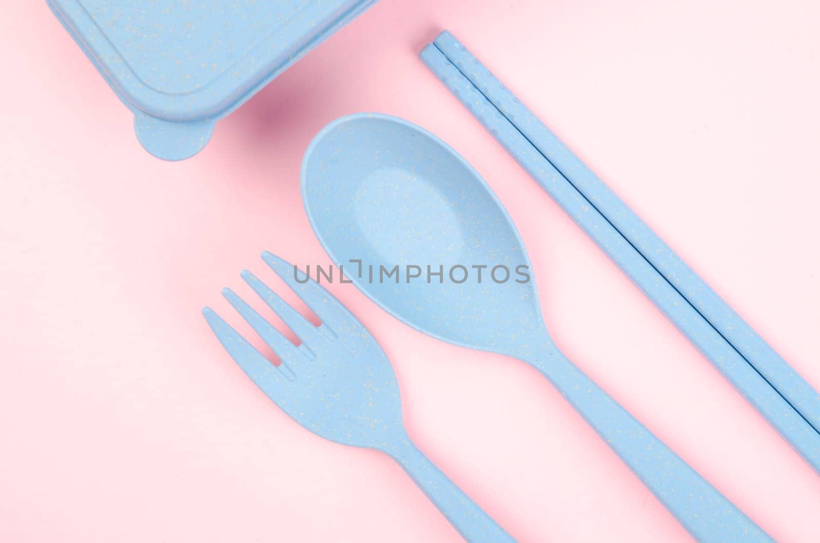Blue Plastic spoons, forks and chopsticks set on pink color background.