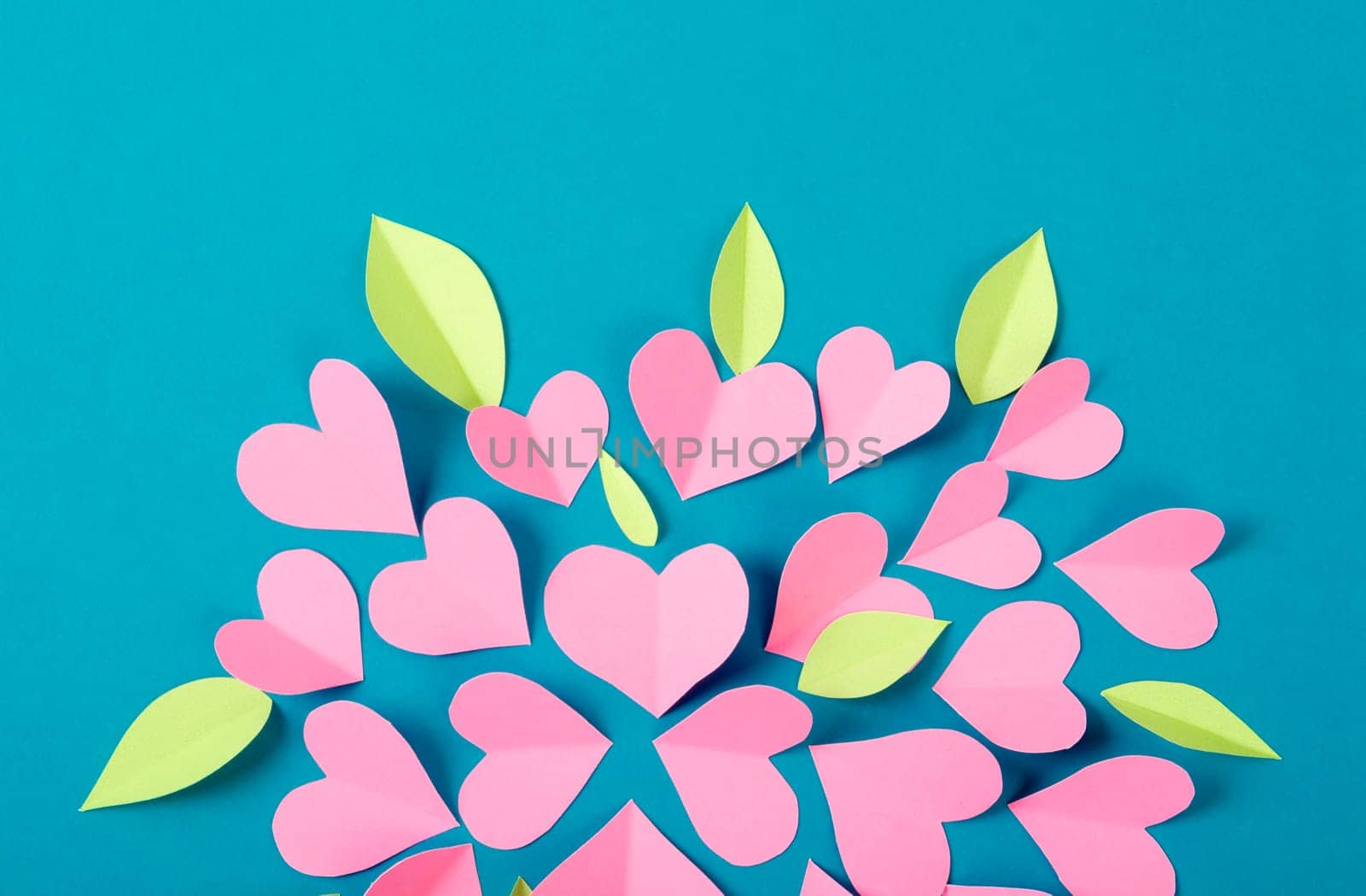 The Pink color heart shape paper cutting on green background. by Gamjai