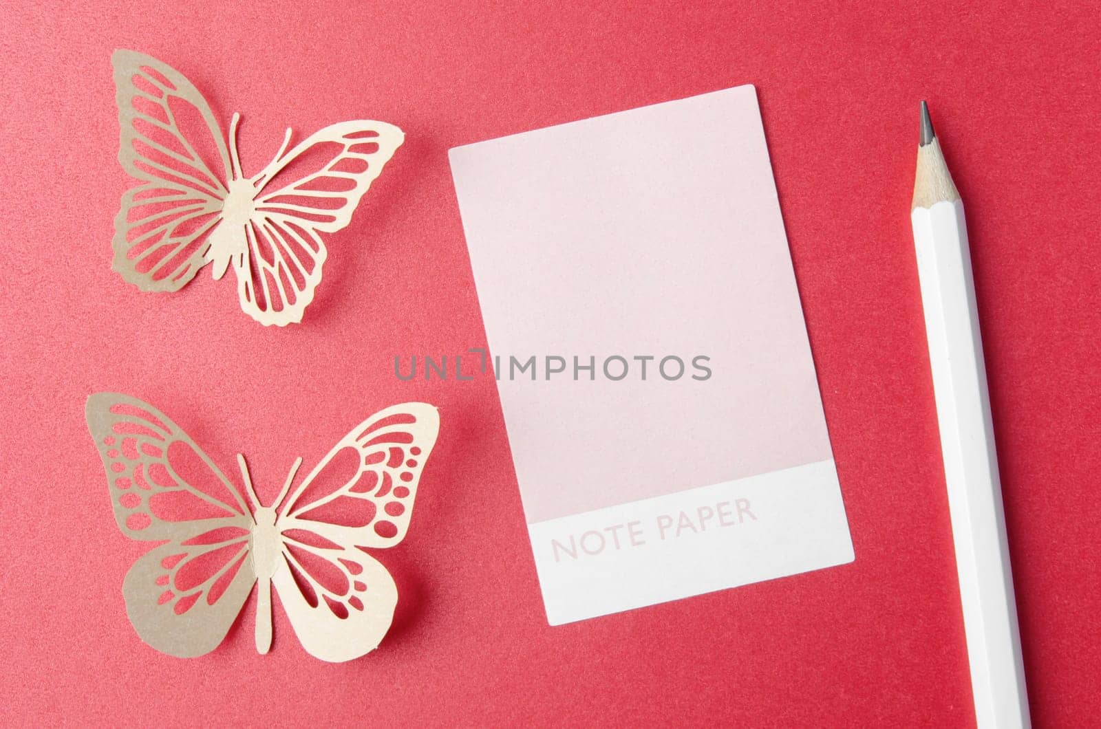 The Blank Note Paper and carve of paper butterfly with pencil on red background, space for text. by Gamjai
