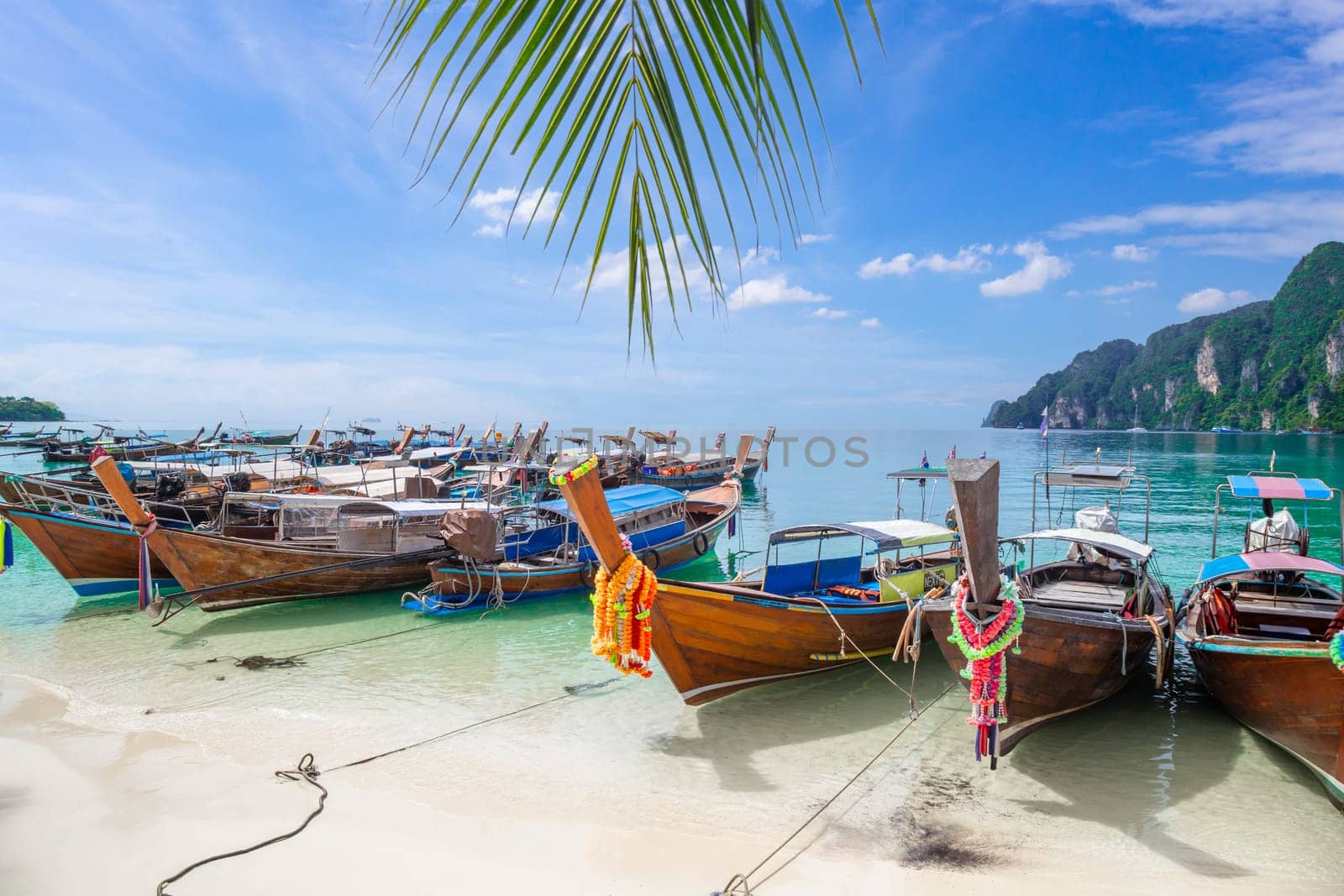 The Thai traditional wooden longtail boat and beautiful beach in Phuket province, Thailand. by Gamjai