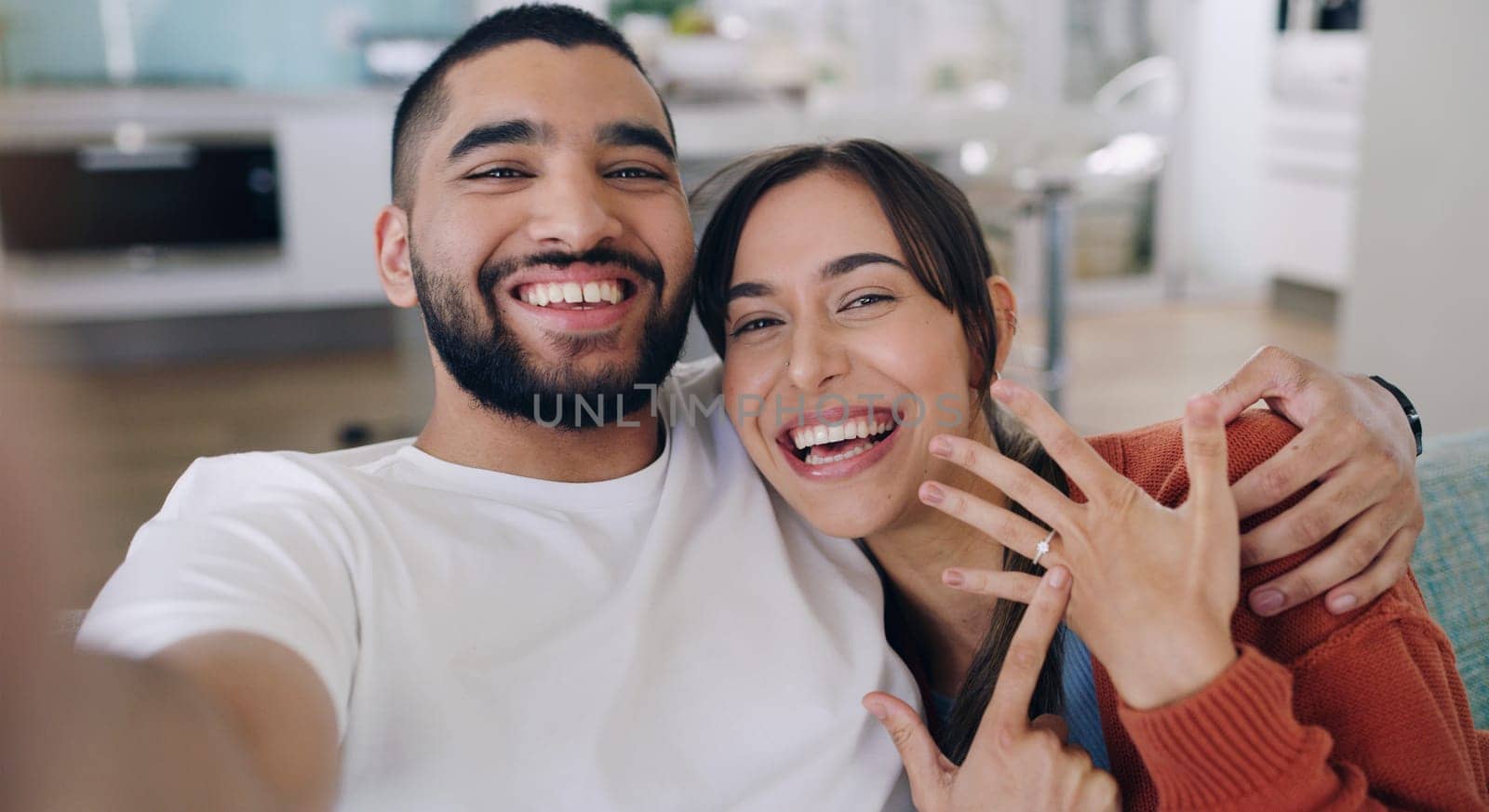 Couple, selfie and engagement ring in living room portrait for happiness, romance and love on social media app. Man, woman and excited for marriage proposal, offer and celebration with smile on blog.