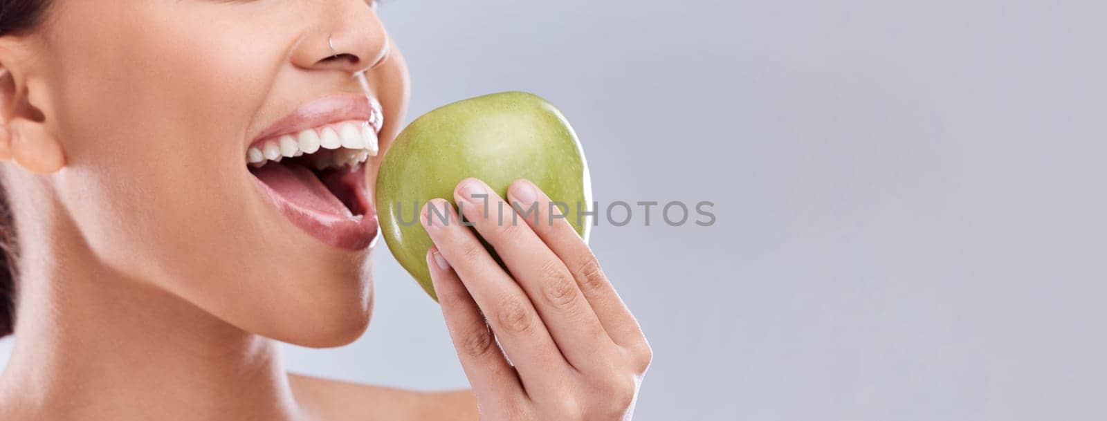 Mockup, apple bite or woman eating in studio on white background for healthy nutrition or clean diet. Closeup, space on banner or open mouth of hungry girl marketing natural green fruit for wellness by YuriArcurs