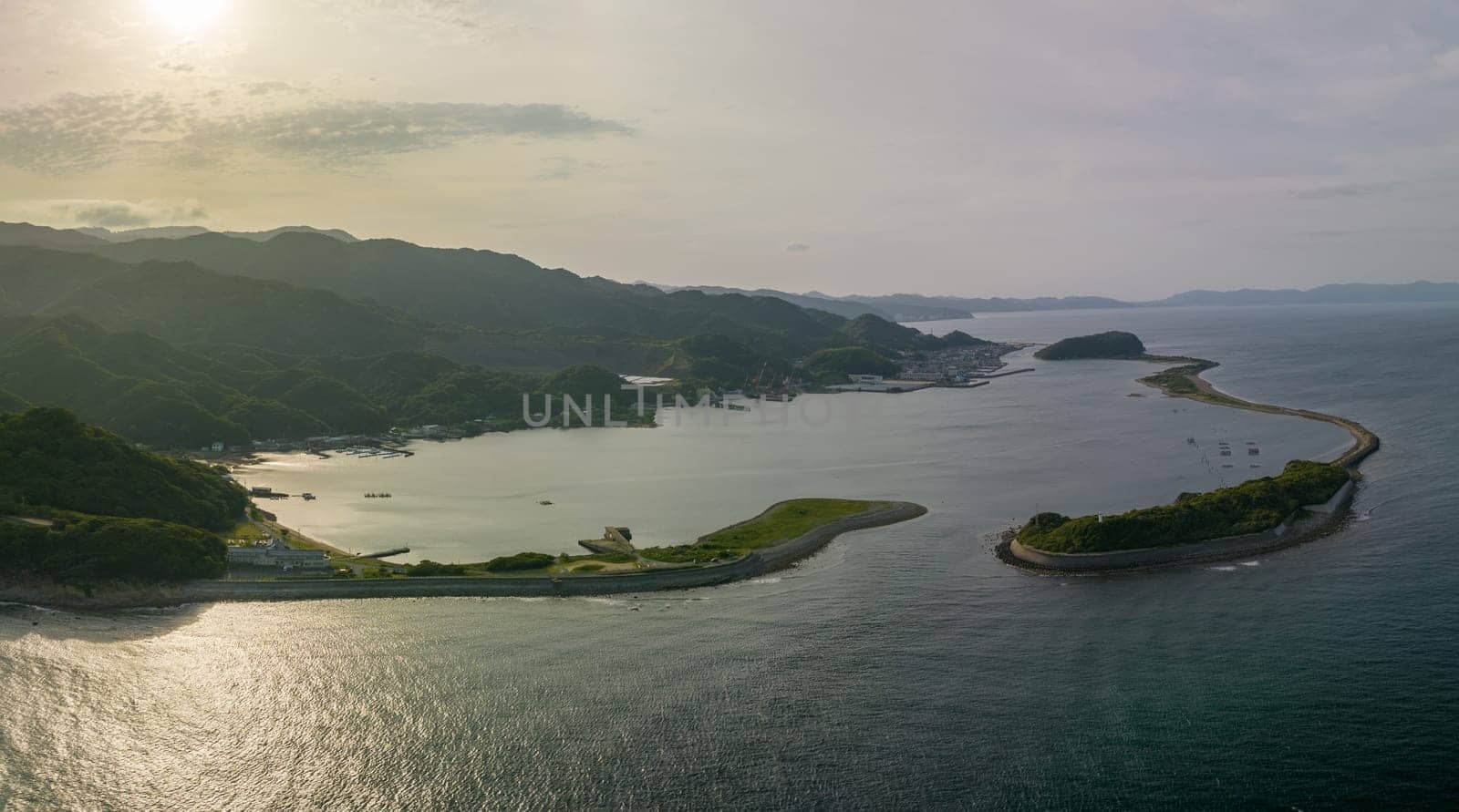 Afternoon sun shines on small coastal bay protected by sandbar island. High quality photo