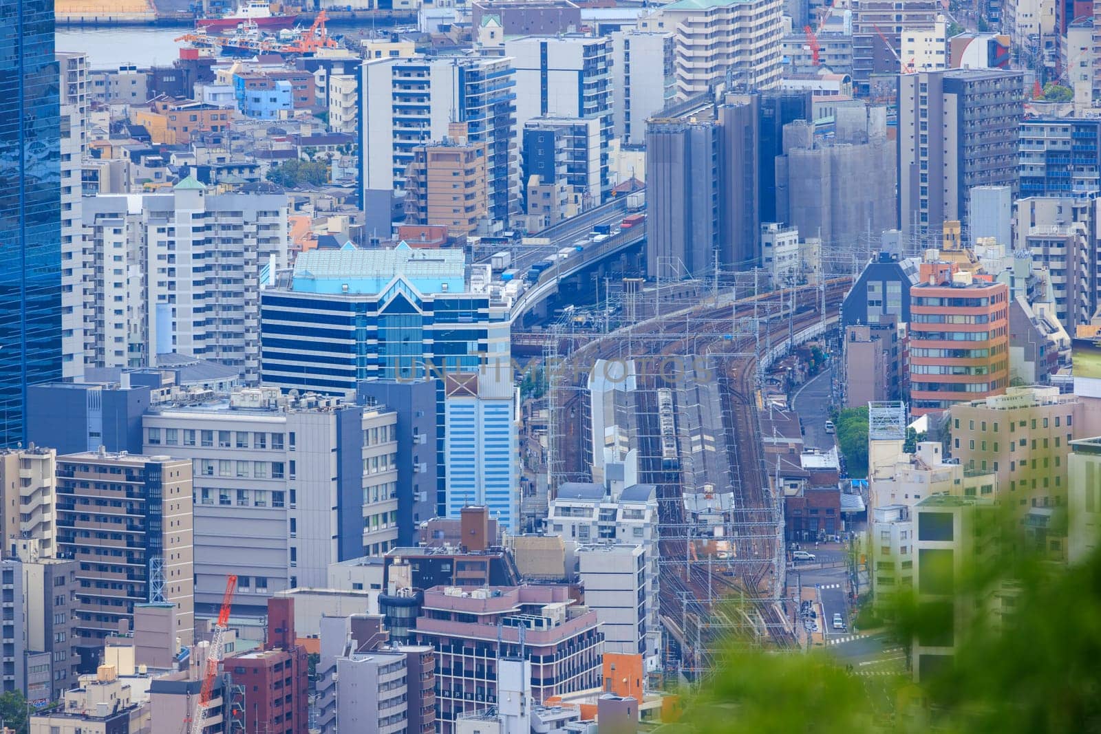 Train on tracks through multi-story buildings in dense city center. High quality photo