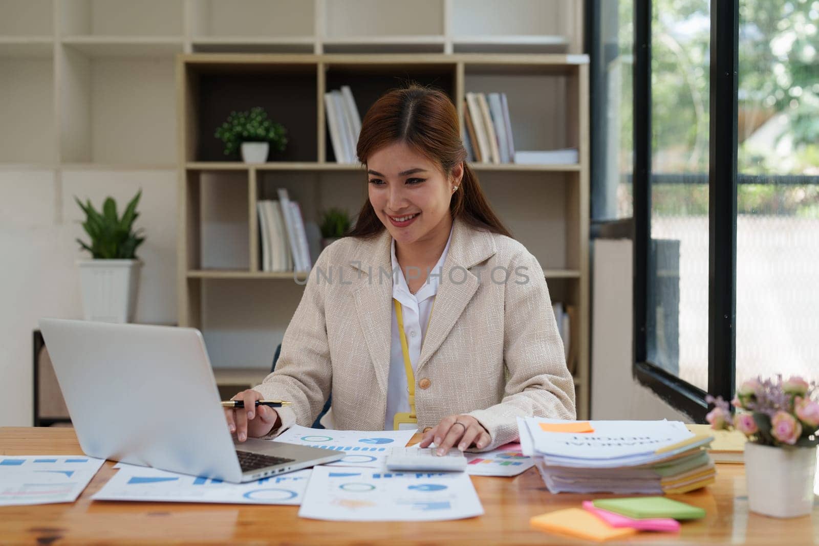 Asian Business person makes analysis and research financial report at office, analyzes profits. Accountant checks status of financial.