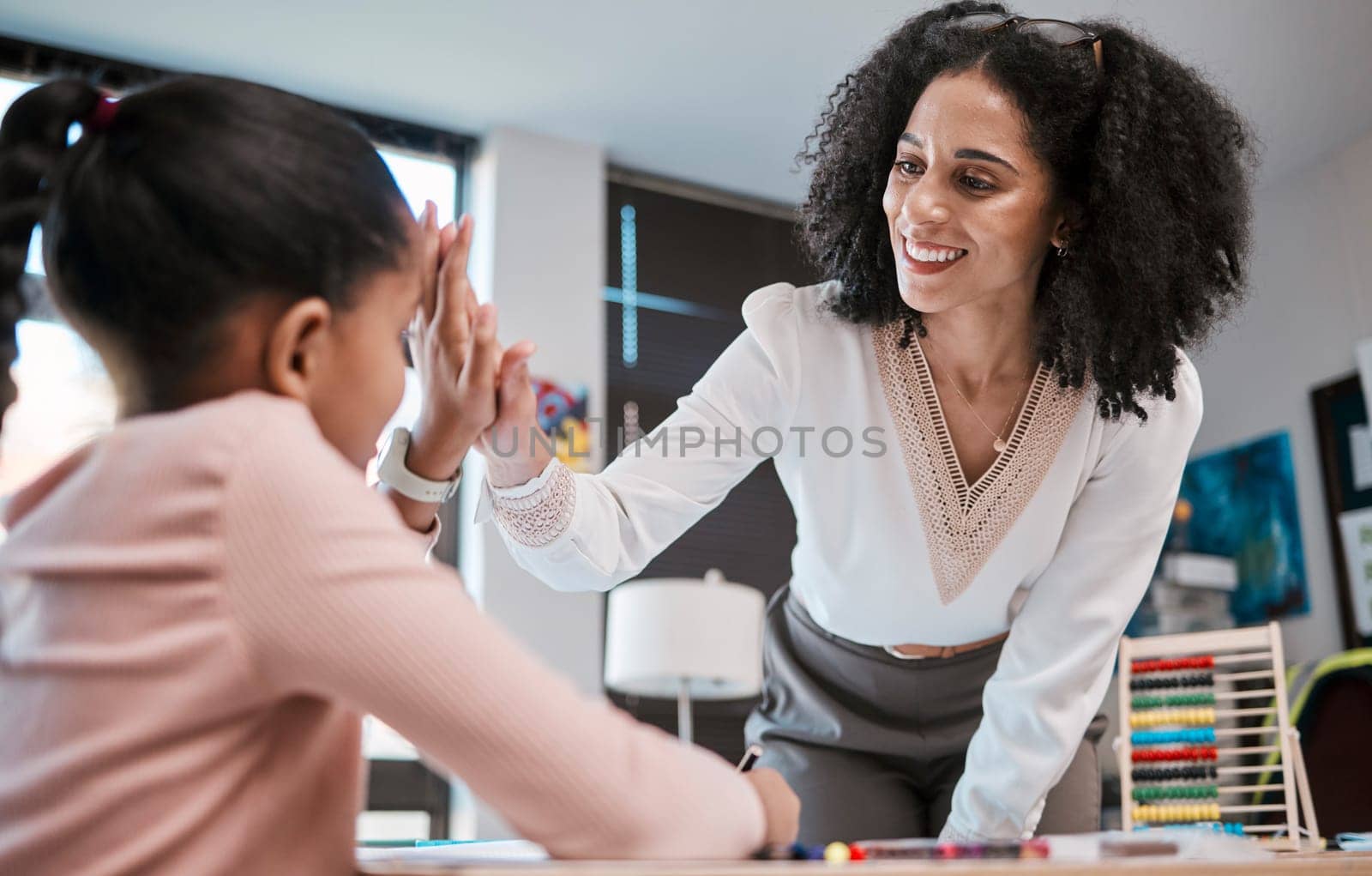 High five, success or teacher in celebration with a student in a classroom with learning development. Goals, education or happy black woman smiles teaching or celebrates a target with a school girl.