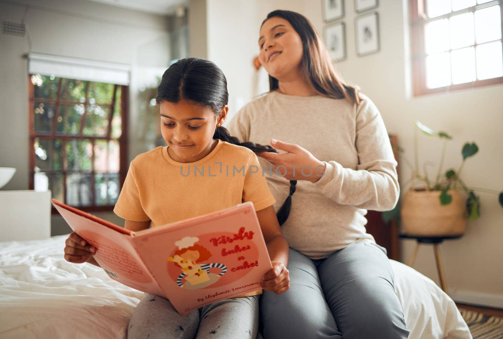 Family, book or education and a girl reading in a bedroom with her mom playing with her hair in their home. Books, learning and love with a mother and daughter bonding while sitting on a bed together.