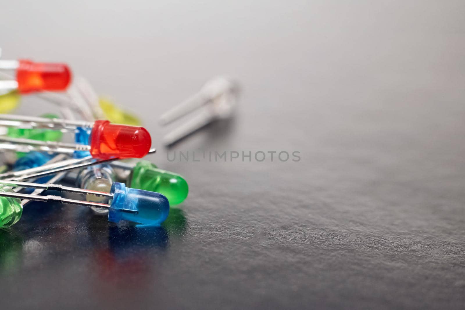 A bunch of multi-colored LEDs on a gray background, close up