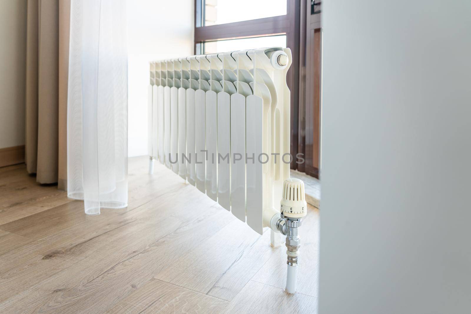 White big radiator near window in a modern room