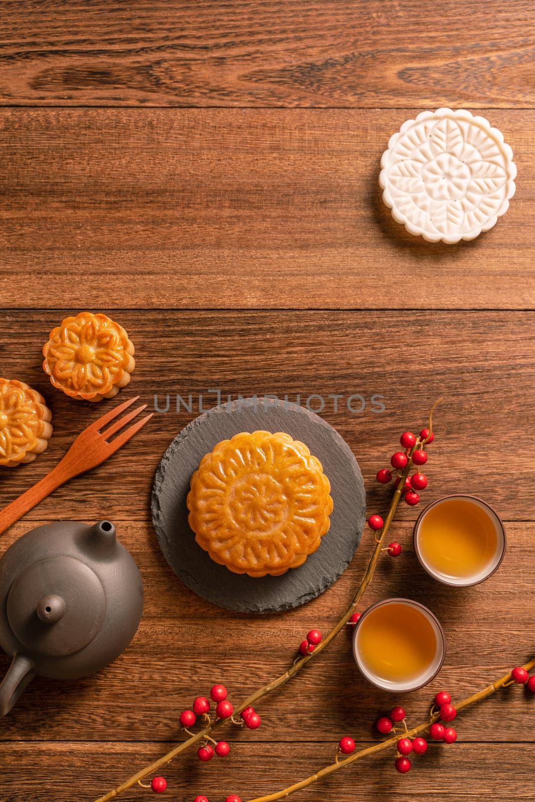 Creative Moon cake Mooncake table design - Chinese traditional pastry with tea cups on wooden background, Mid-Autumn Festival concept, top view, flat lay.