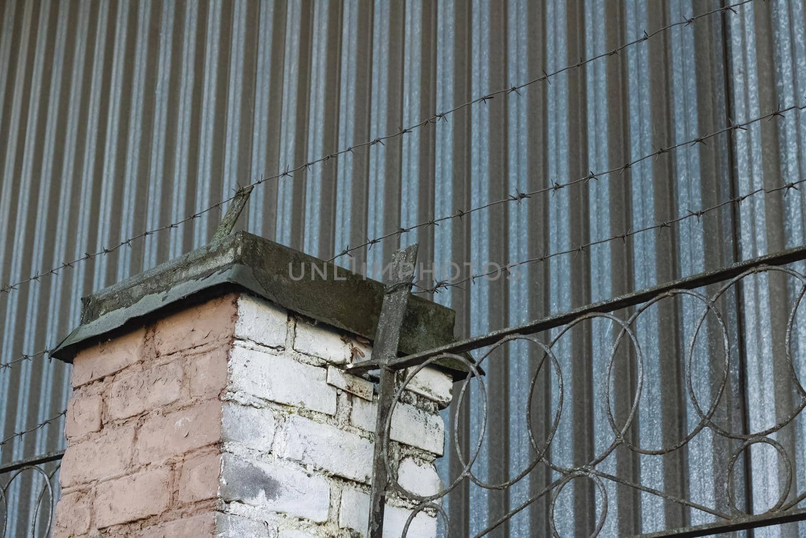 Barbed wire on a high old fence close up