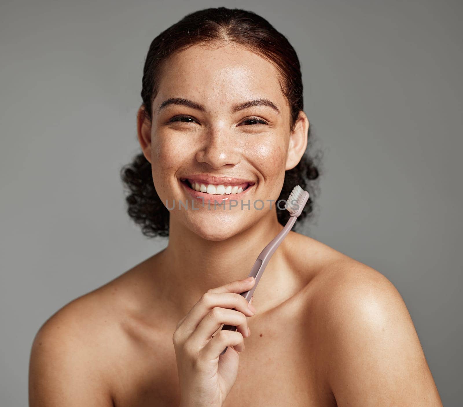 Dental portrait, toothbrush and a woman brushing teeth for hygiene, cleaning and teeth whitening for wellness. Face of happy female with a smile for oral health, healthy mouth and self care in studio.