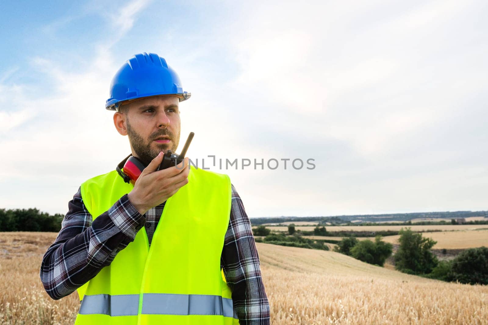 Male construction worker communicating with walkie-talkie. Copy space. Construction concept.