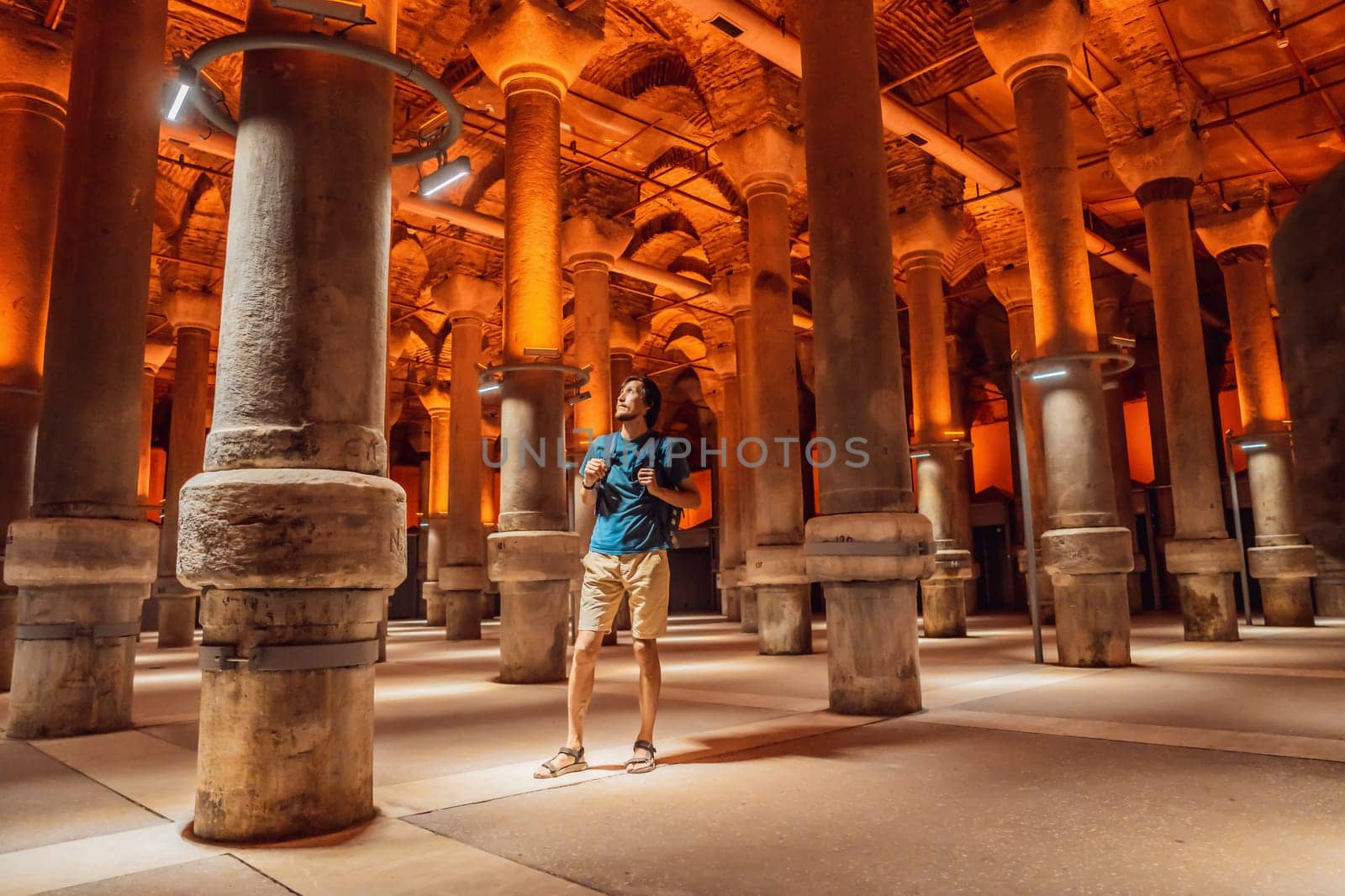 Man tourist enjoying Beautiful cistern in Istanbul. Cistern - underground water reservoir build in 6th century, Istanbul, Turkey, Turkiye.