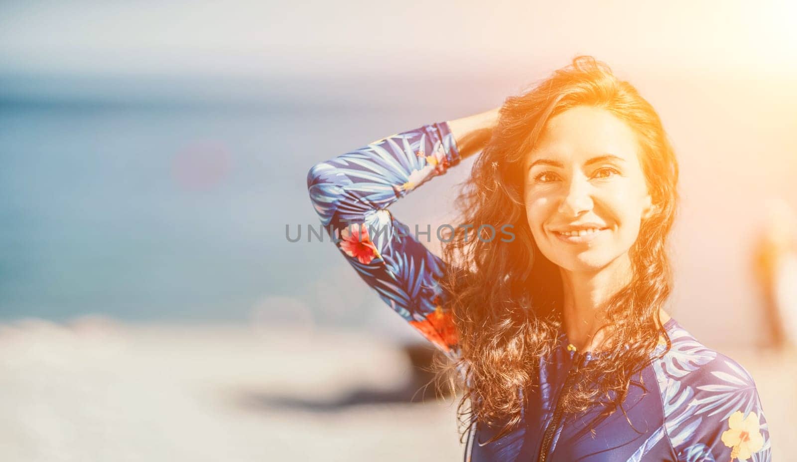 Portrait woman sea. Well looking middle aged smiling woman with black hair, fitness instructor in blue swimwear on the rocky beach near the sea. Female fitness yoga routine concept. Healthy lifestyle. by panophotograph