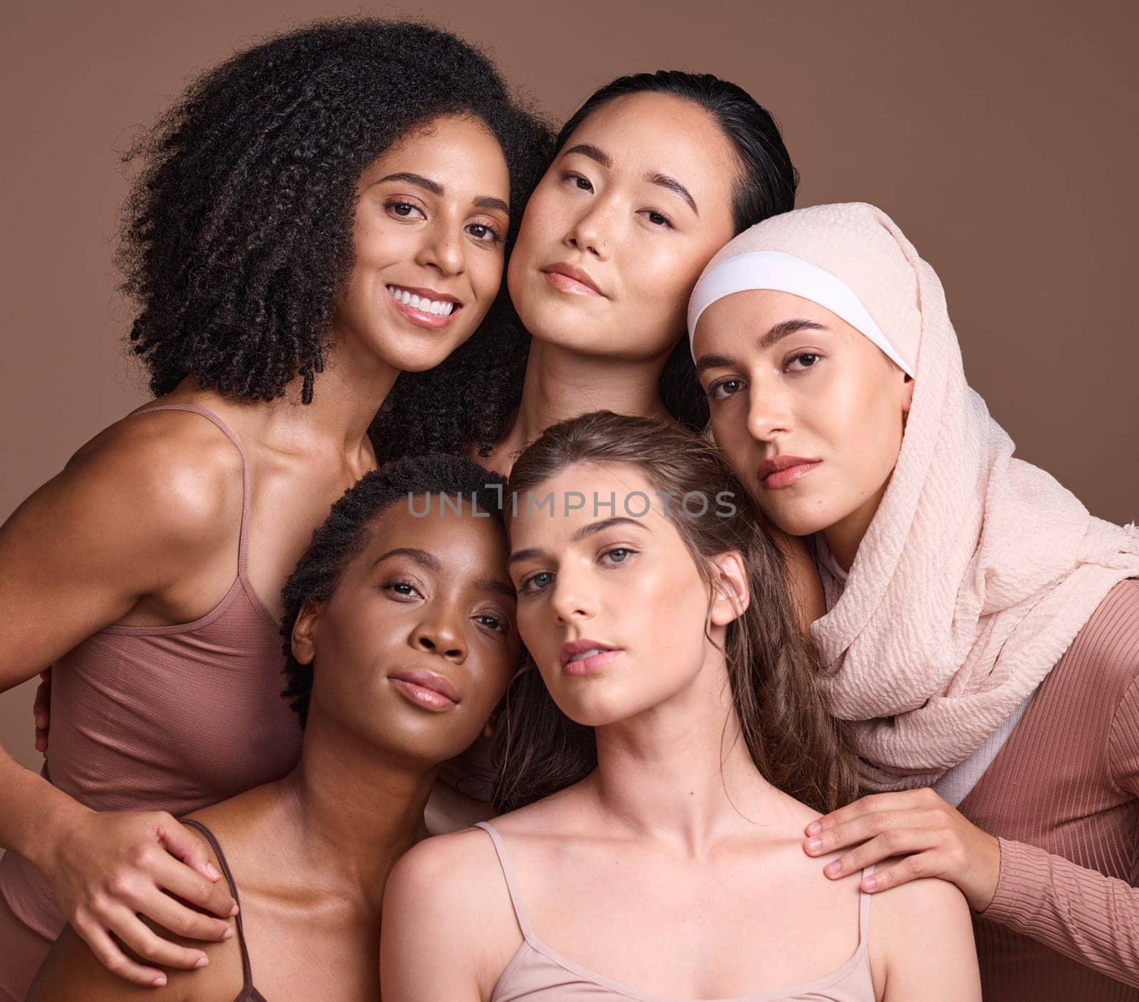 Diversity, beauty and portrait of a group of women in studio for skincare, makeup or cosmetic routine. Feminism, female empowerment and face of multicultural girl friends isolated by brown background.