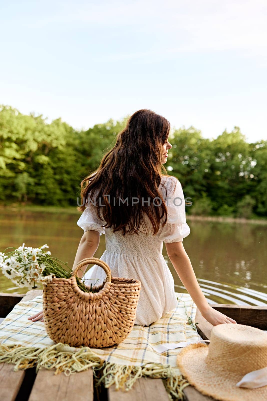 close up photo of a woman sitting by the lake with a wicker bag full of daisies by Vichizh